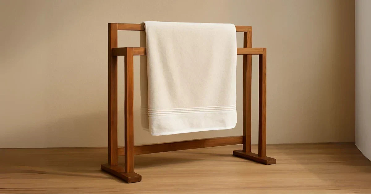 Elegant wooden towel rack with a white towel displayed on a wooden surface and beige background