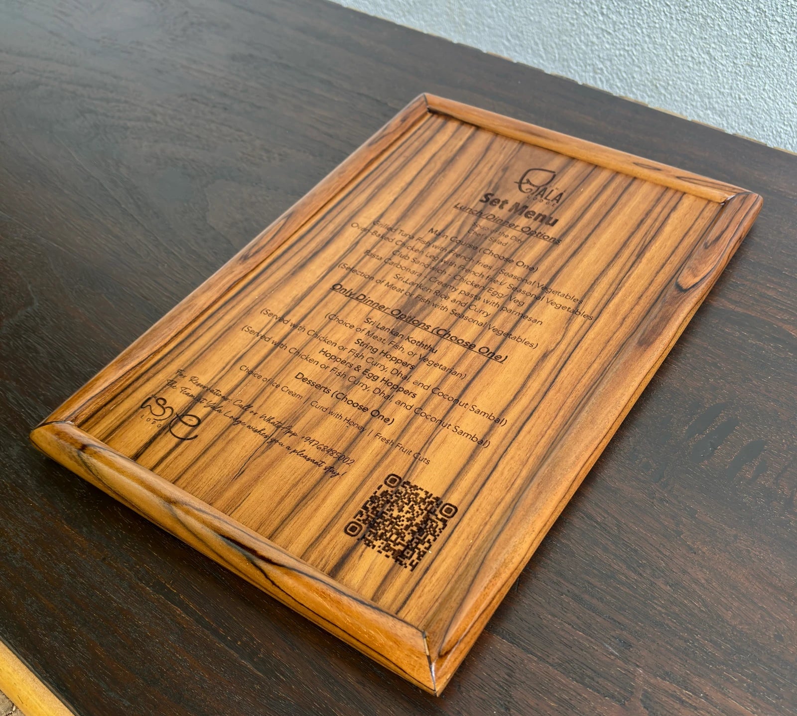 Wood Ceylon wooden laser engraved menu card with detailed food options on a dark wood table