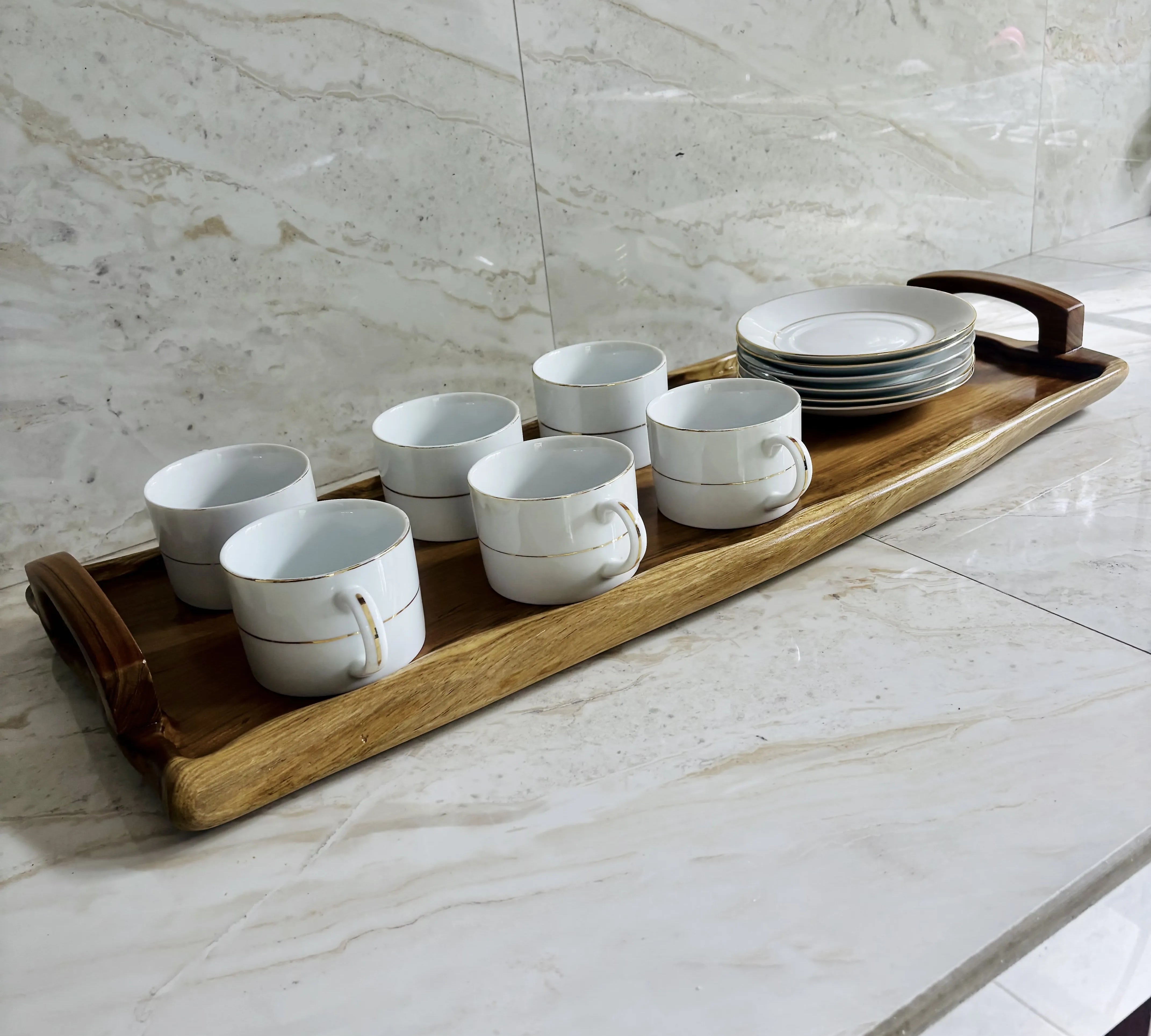 Wood Ceylon wooden serving tray holding six white coffee cups and stacked plates on marble surface