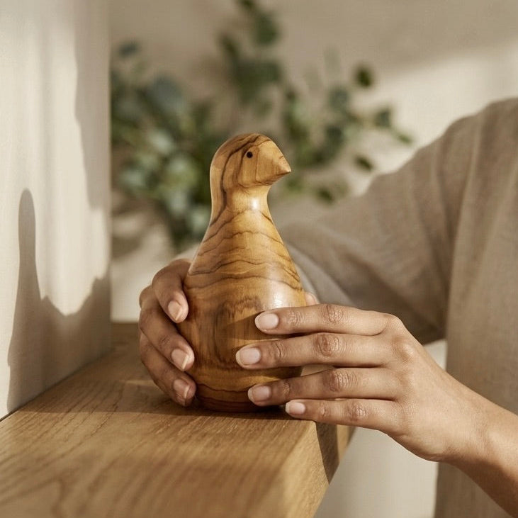 Hand-carved teak bird sculpture, natural wood grain side view