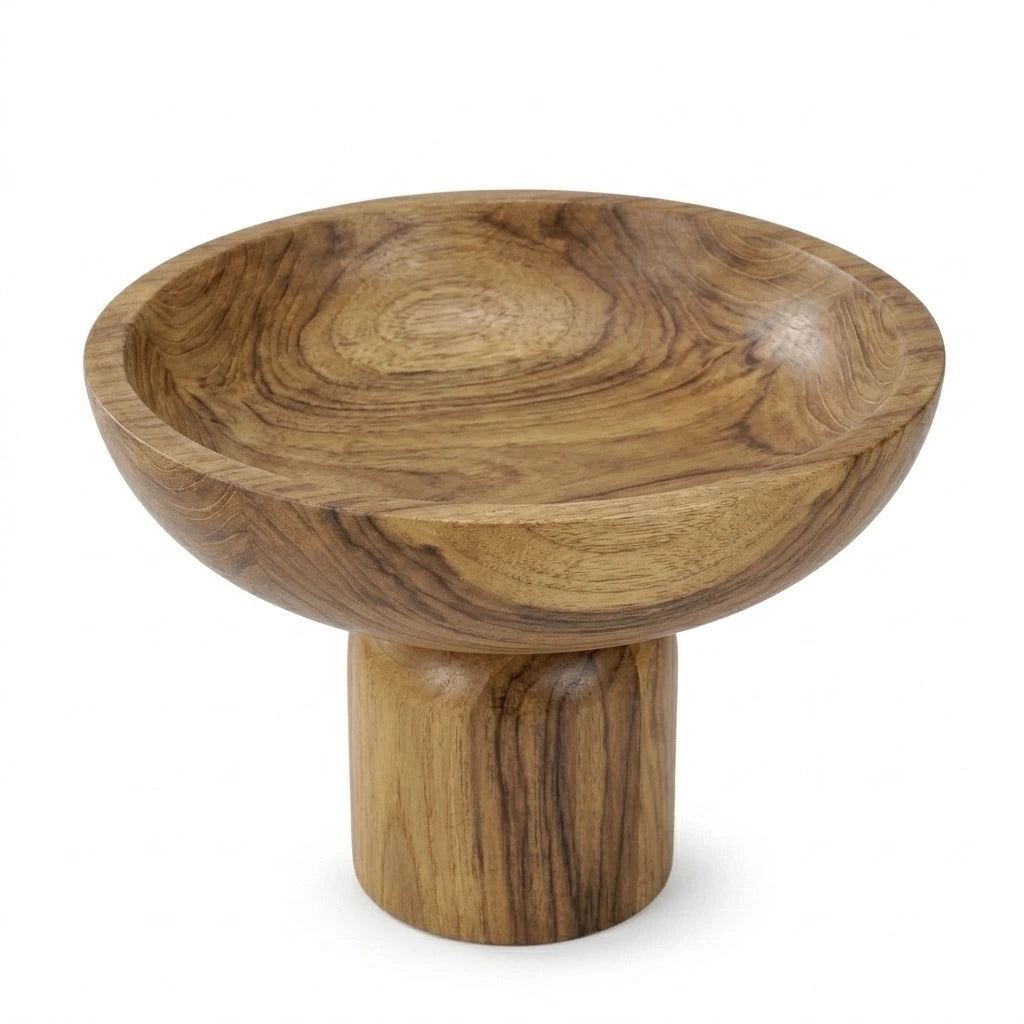 Wooden pedestal bowl holding fresh fruit on a linen-draped dining table