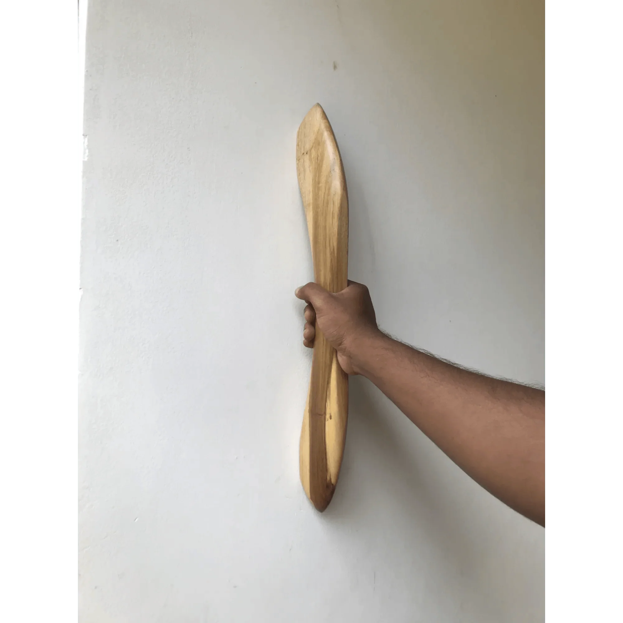 Hand holding a wooden closet door handle with a sleek design against a white background