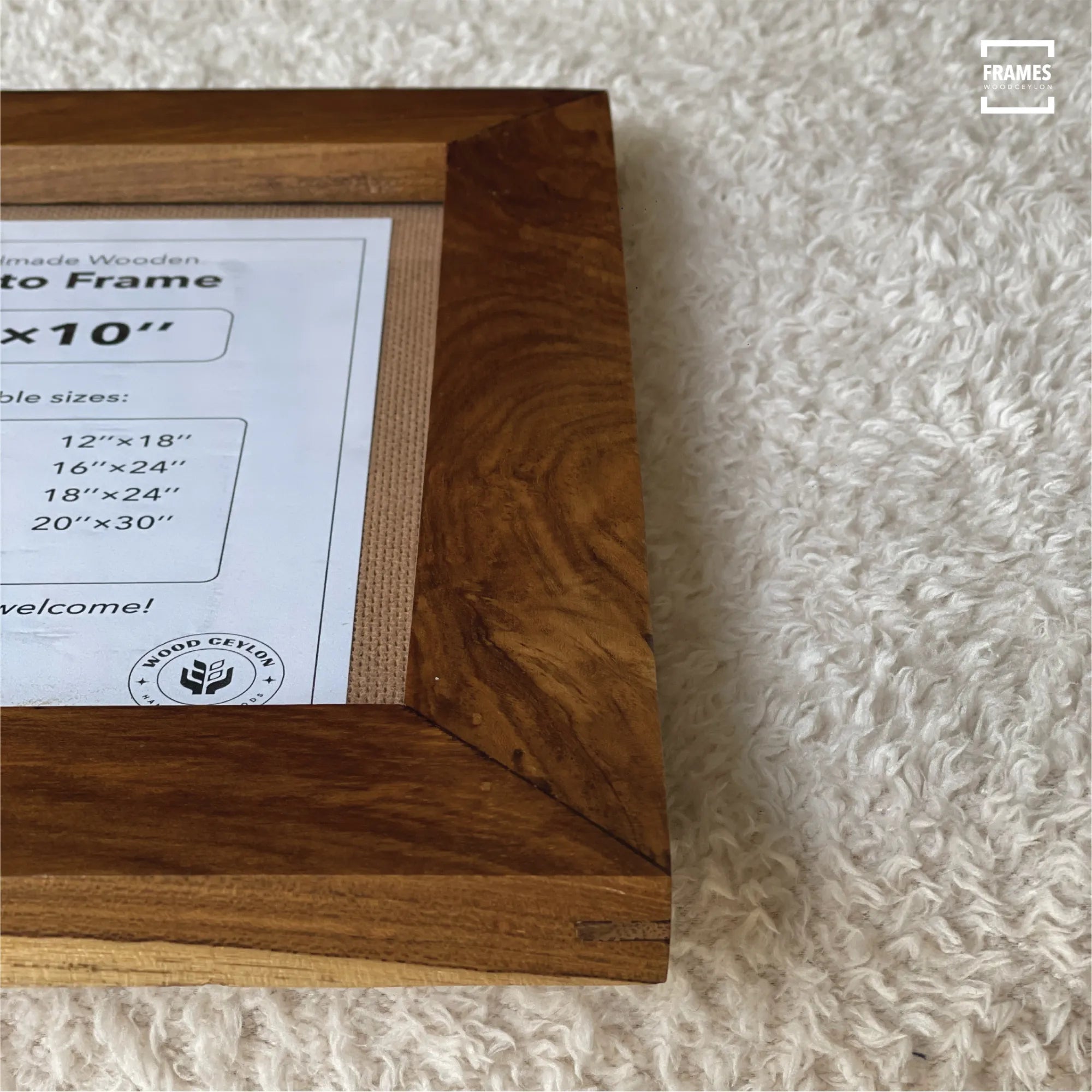 Wood Ceylon wooden picture frame with rich natural wood grain on a textured white surface