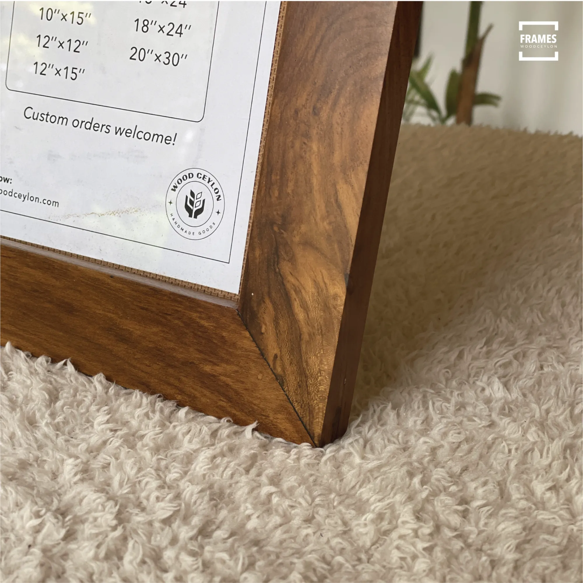 Close-up of Wood Ceylon polished wooden picture frame corner on a textured beige surface