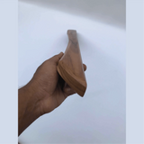 Hand holding a sleek wooden Handmade Barn Door Handles by Wood Ceylon against a plain background