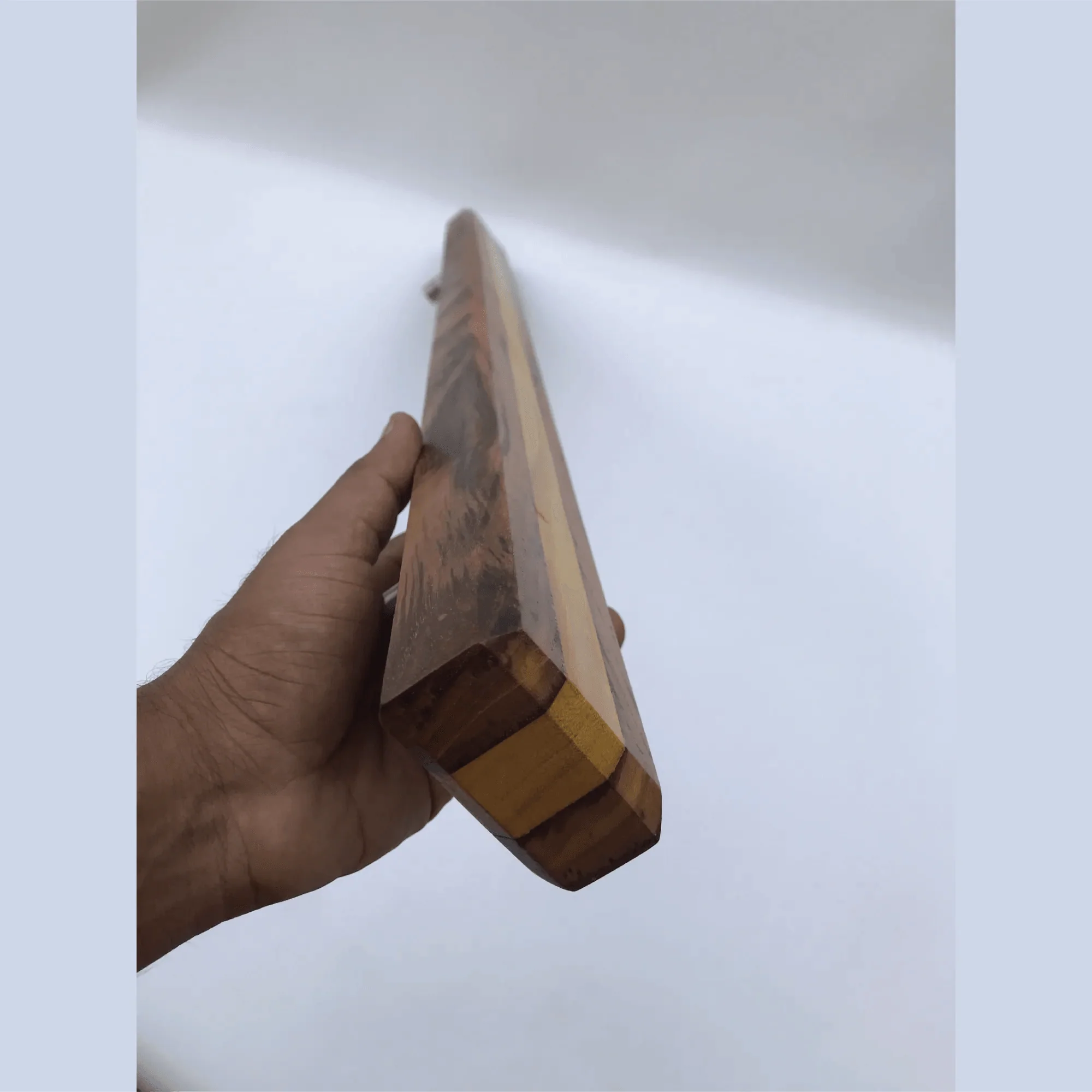 Hand holding a large wooden door handle with natural wood grain from Wood Ceylon