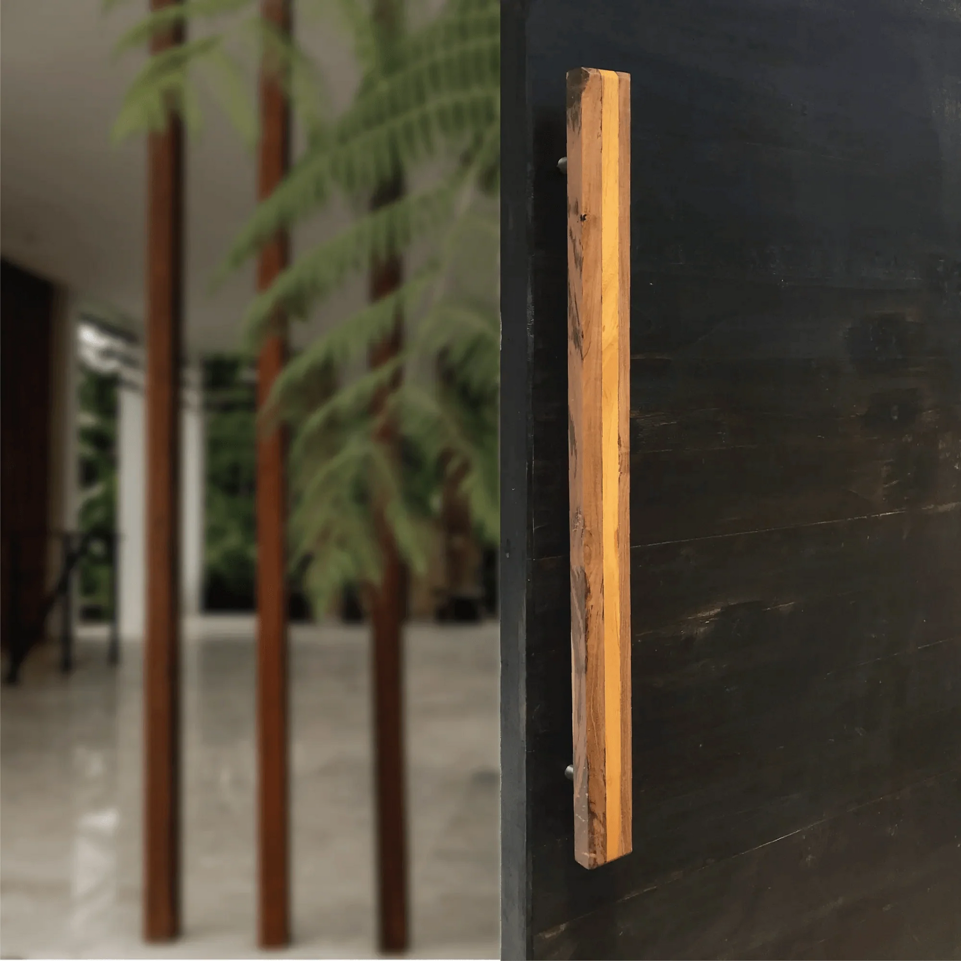 Large wooden door handle mounted on a dark door showcasing natural wood texture by Wood Ceylon