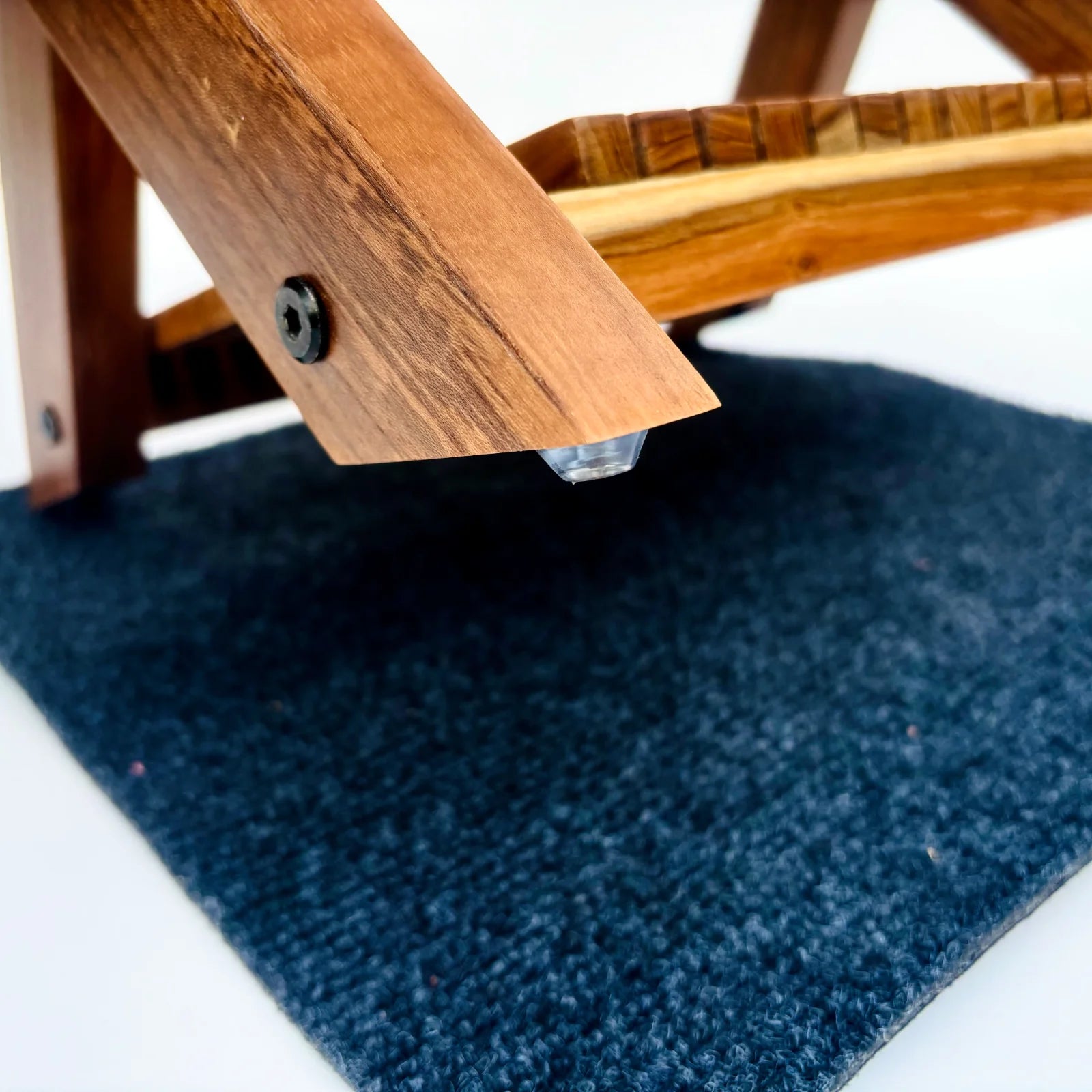Close-up of Wood Ceylon small dish drying rack wooden leg with protective rubber foot on dark mat