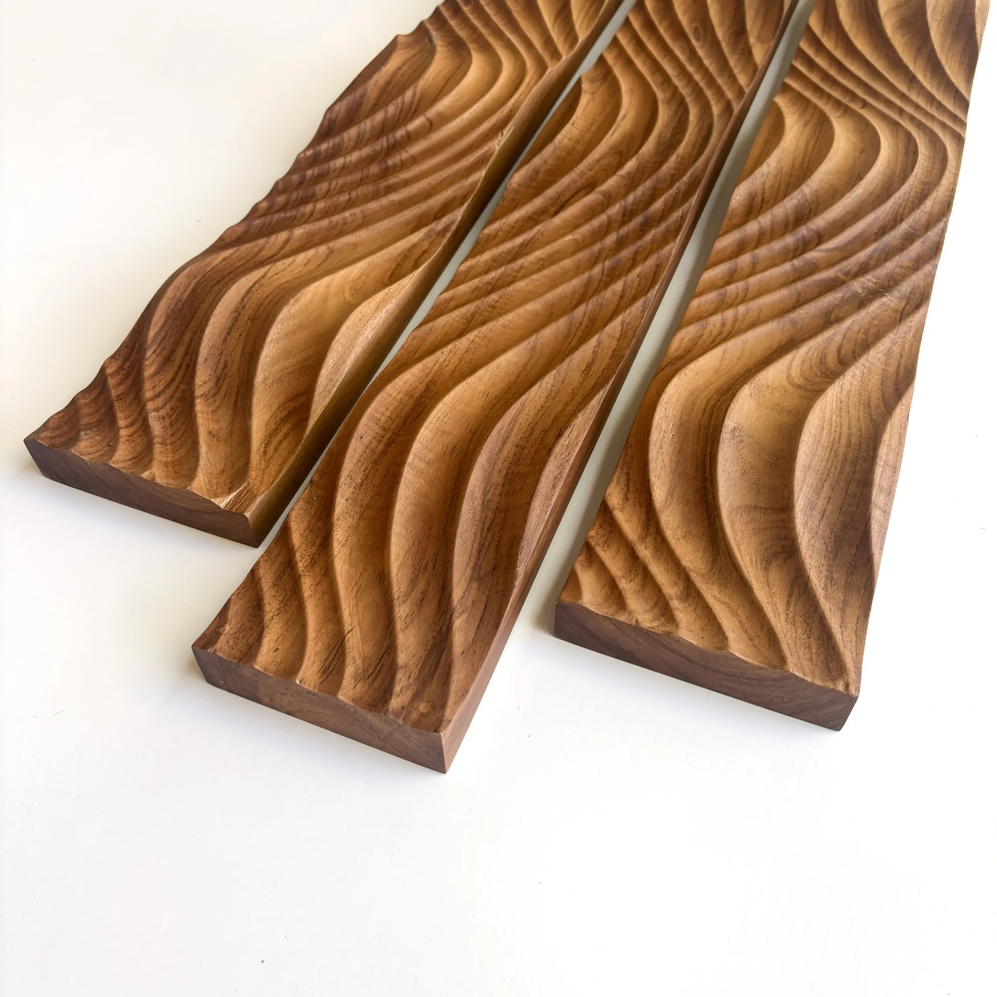 Three beautifully carved solid teak wood panels featuring a wavy design for elegant home decor