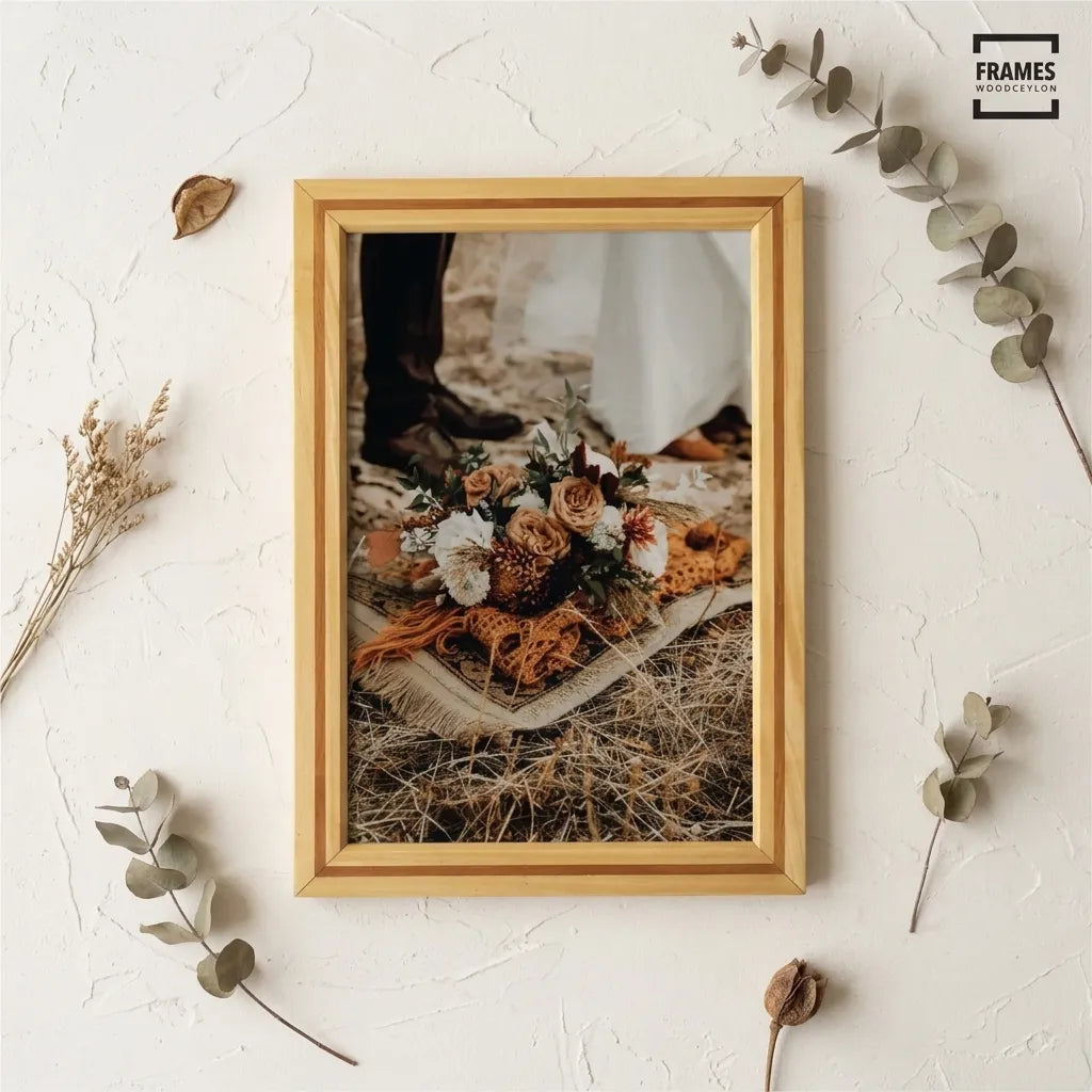 Front view of a striped teak and satin wood picture frame displaying a wedding bouquet photo, styled with dried foliage.