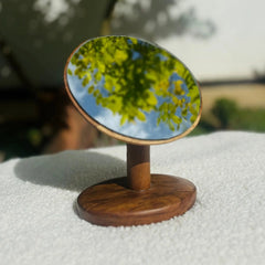 Wood Ceylon tabletop vanity mirror teak with round reflective surface and wooden base on white cloth