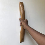 Teak wooden door handle being held, showcasing its smooth curved design and natural wood grain