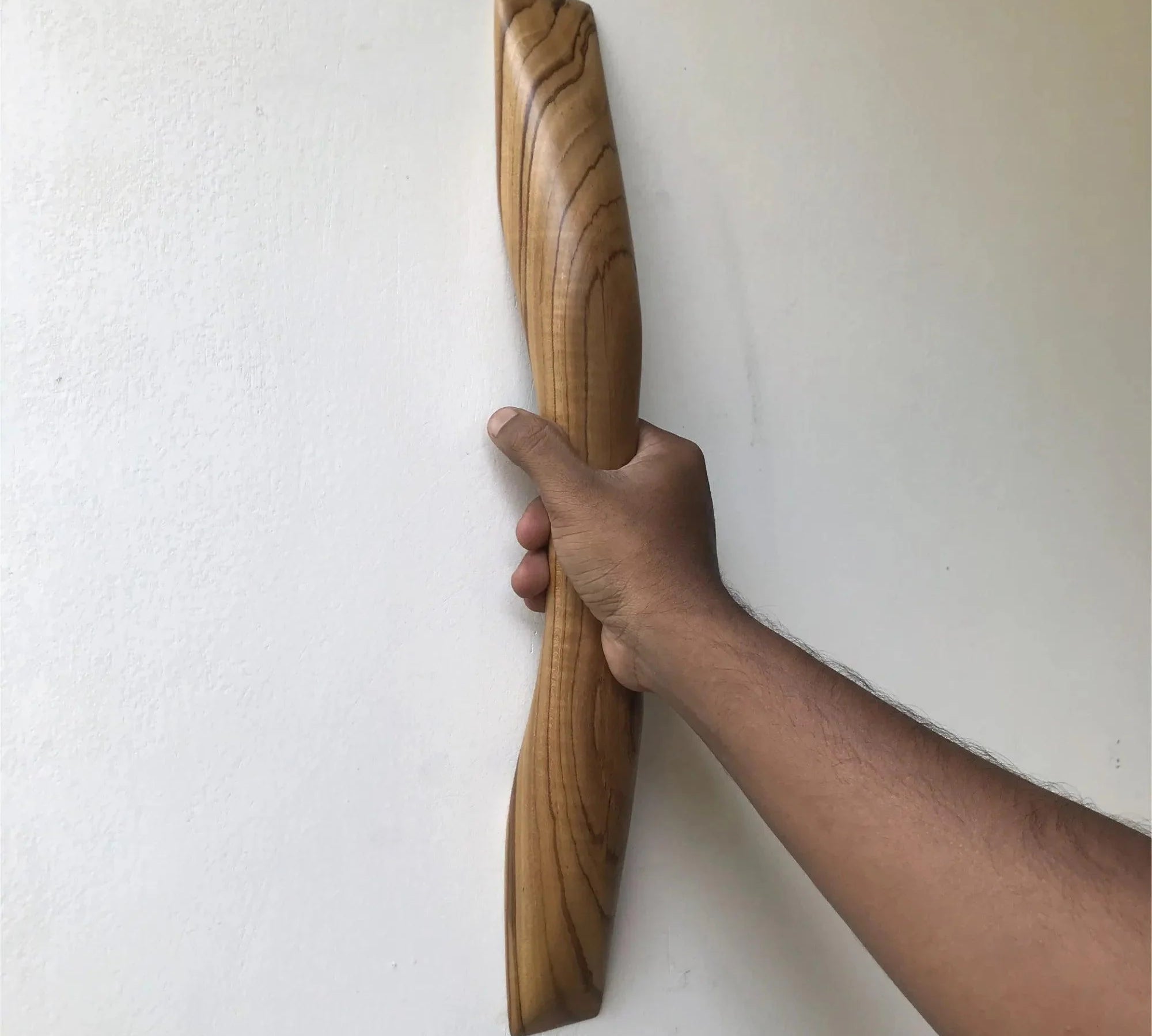 Teak wooden door handle being held, showcasing its smooth curved design and natural wood grain