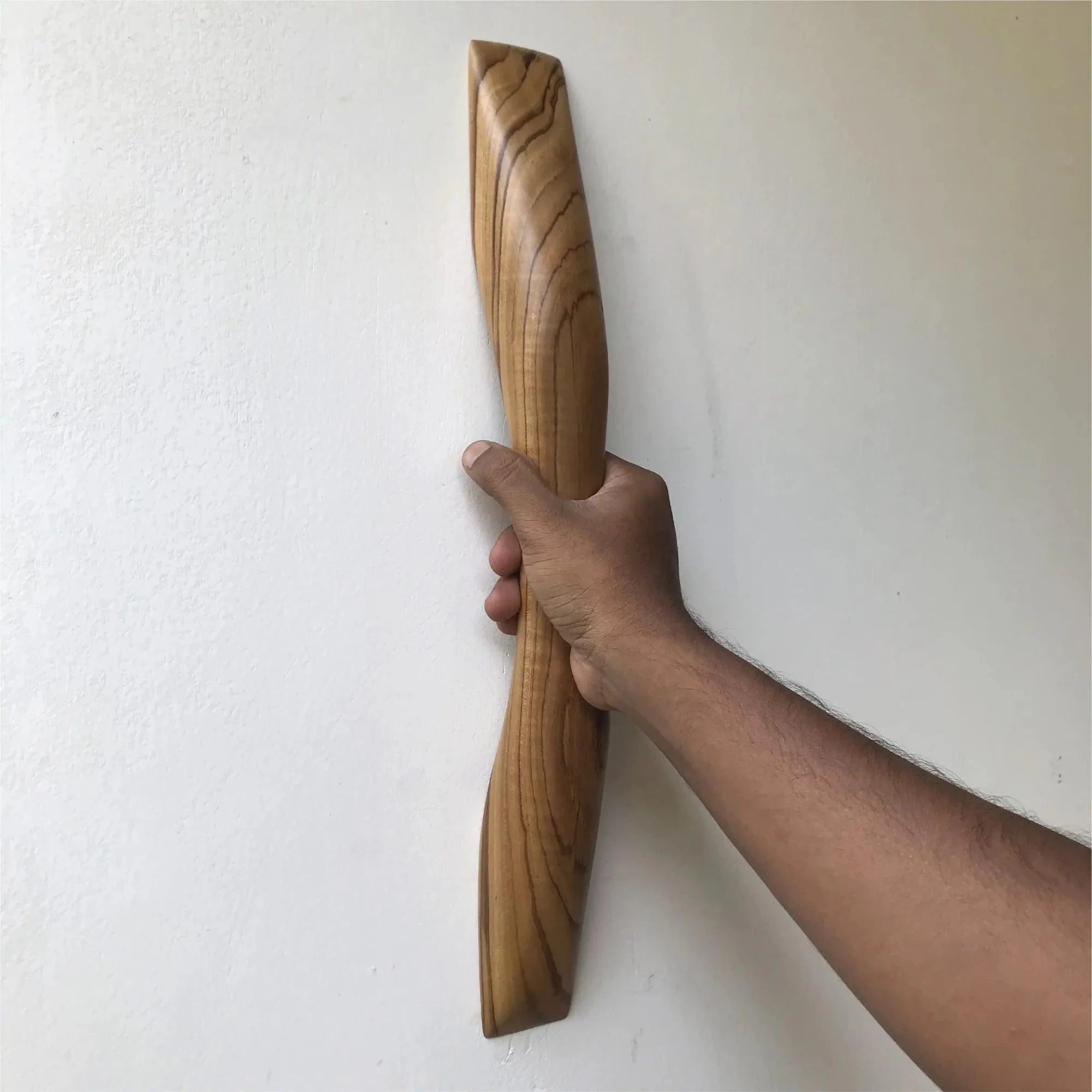 Teak wooden door handle being held, showcasing its smooth curved design and natural wood grain