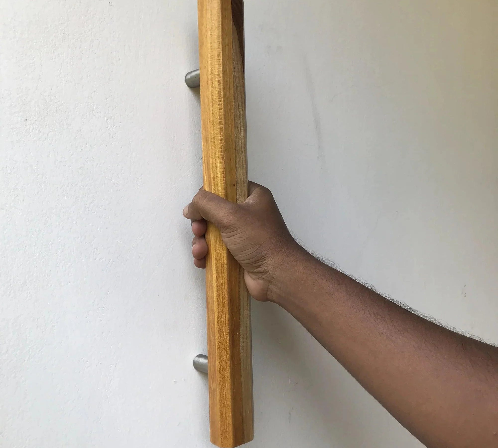 Natural wood barn door handle in hand showcasing rustic design and sturdy grip for doors