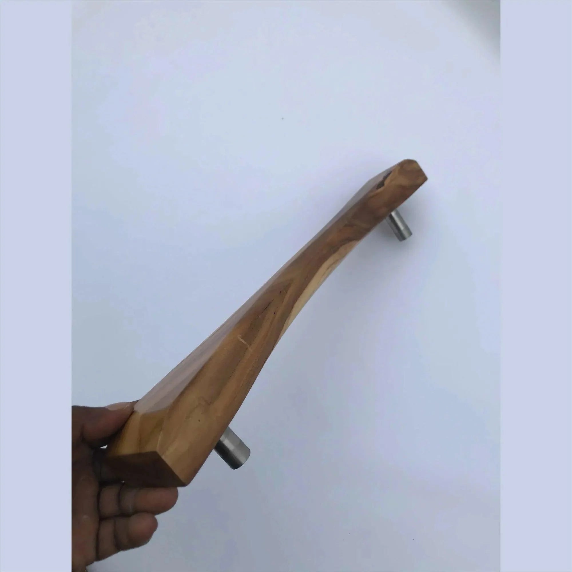 Wood Ceylon wooden sliding door handle with metal mounts held against a white background