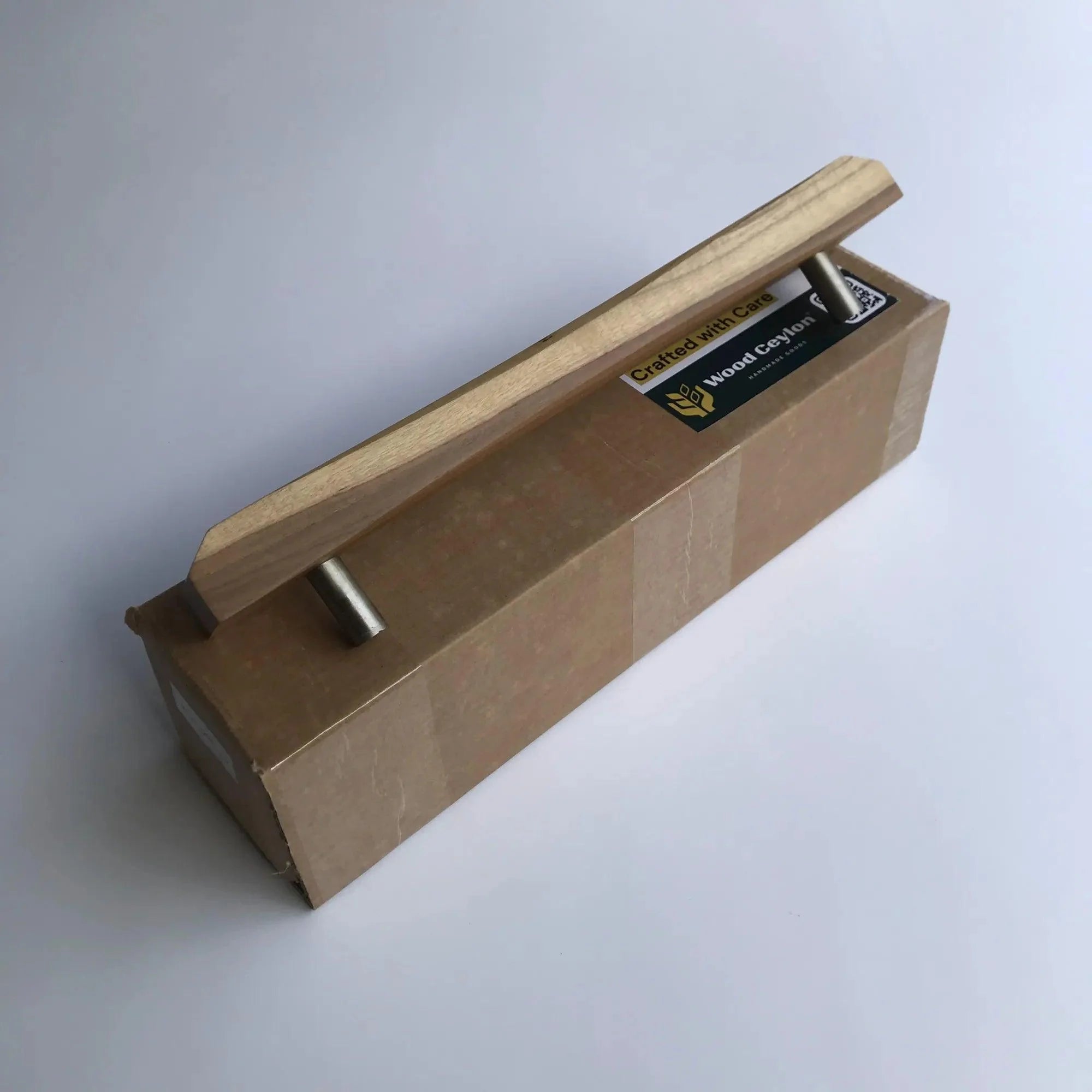 Wood Ceylon sliding door handle made of light wood with metal mounts on packaging box