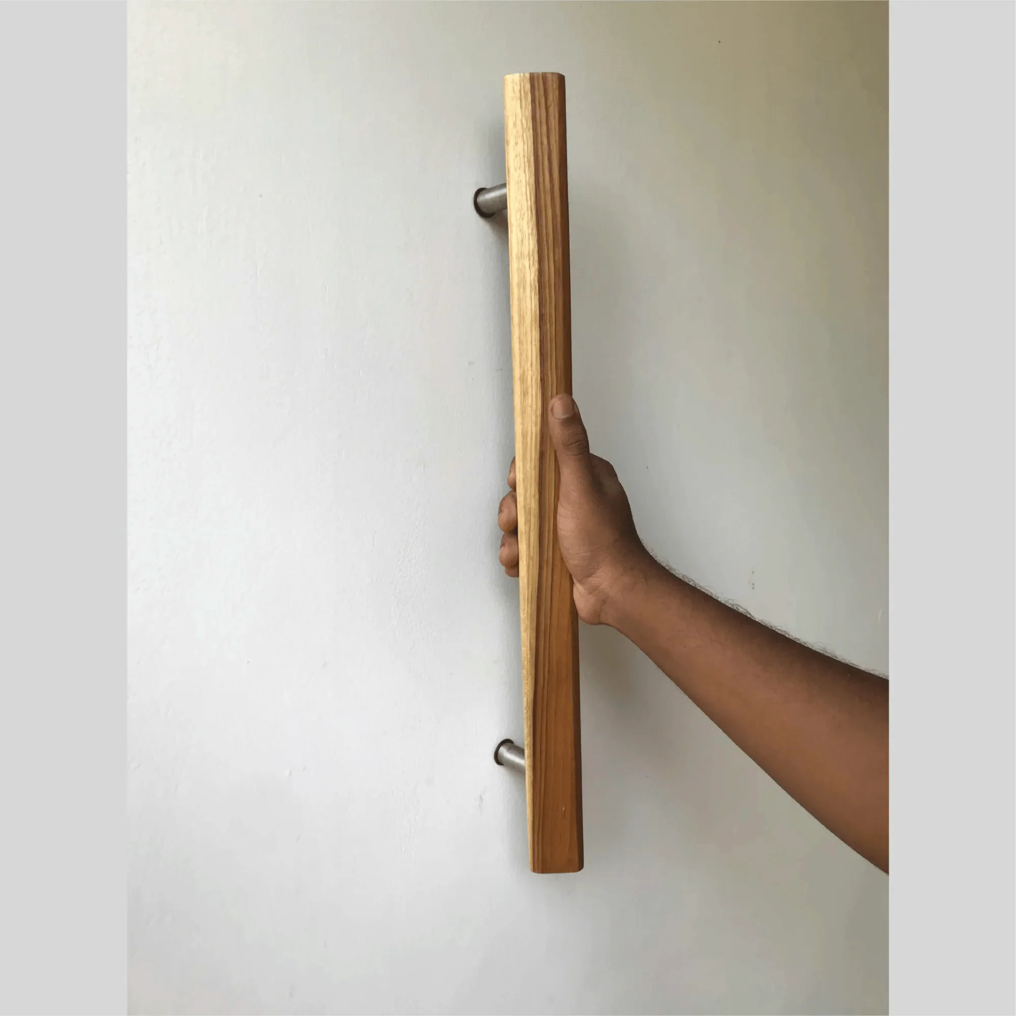 Hand holding a Wood Storm Door Handle mounted on a white door by Wood Ceylon