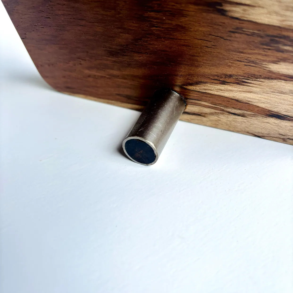 Close-up of the wooden base and metal stand of a personalized qr code sign by Wood Ceylon on a white surface