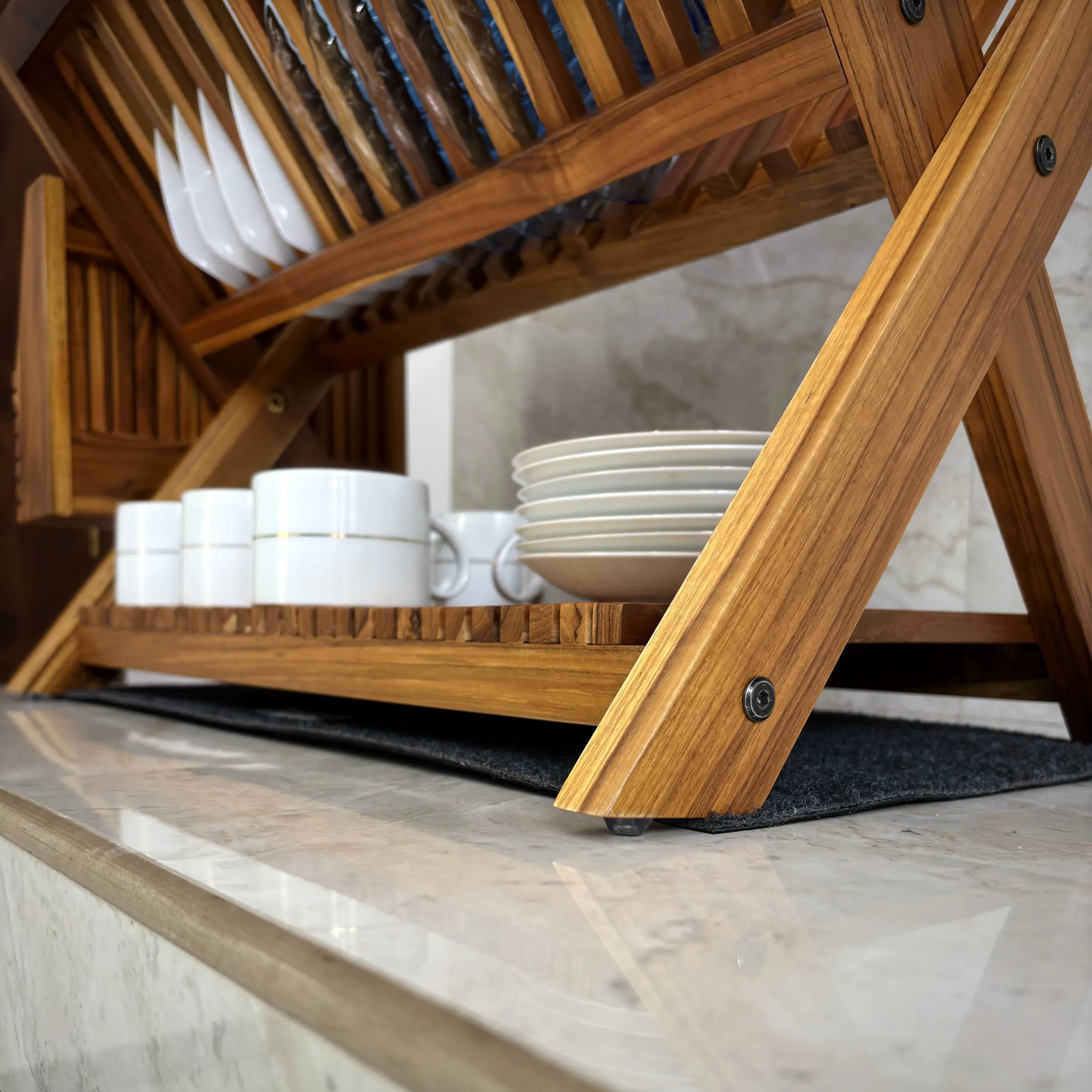 Wood Ceylon wooden dish drying rack holding white plates and cups on kitchen countertop