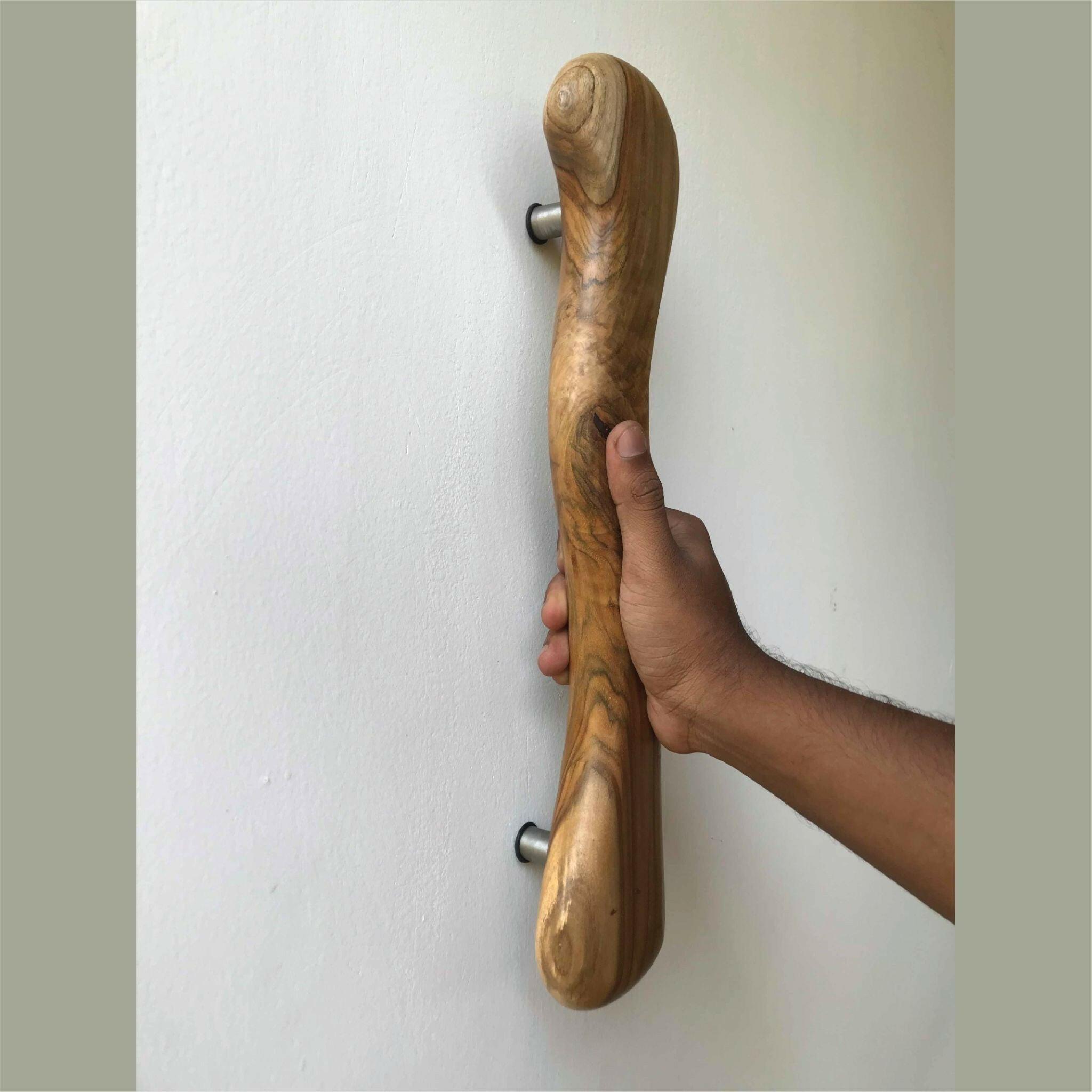 Wood Ceylon wooden door handle mounted on white wall held by hand