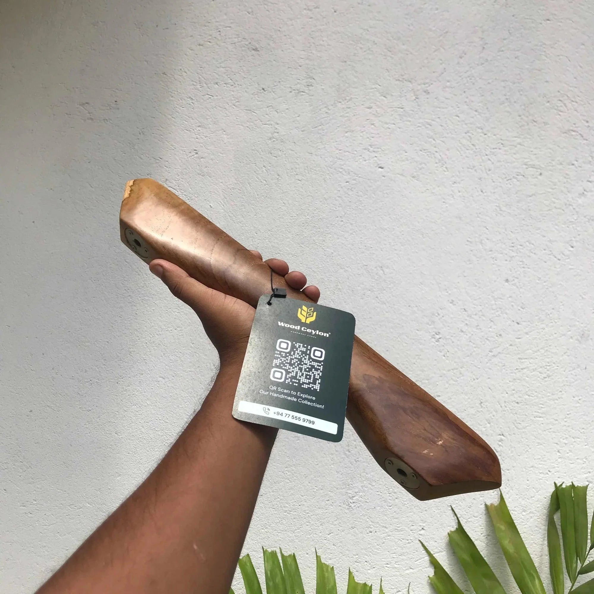 Wood Ceylon handcrafted wooden front door handle hardware with natural finish held against white wall