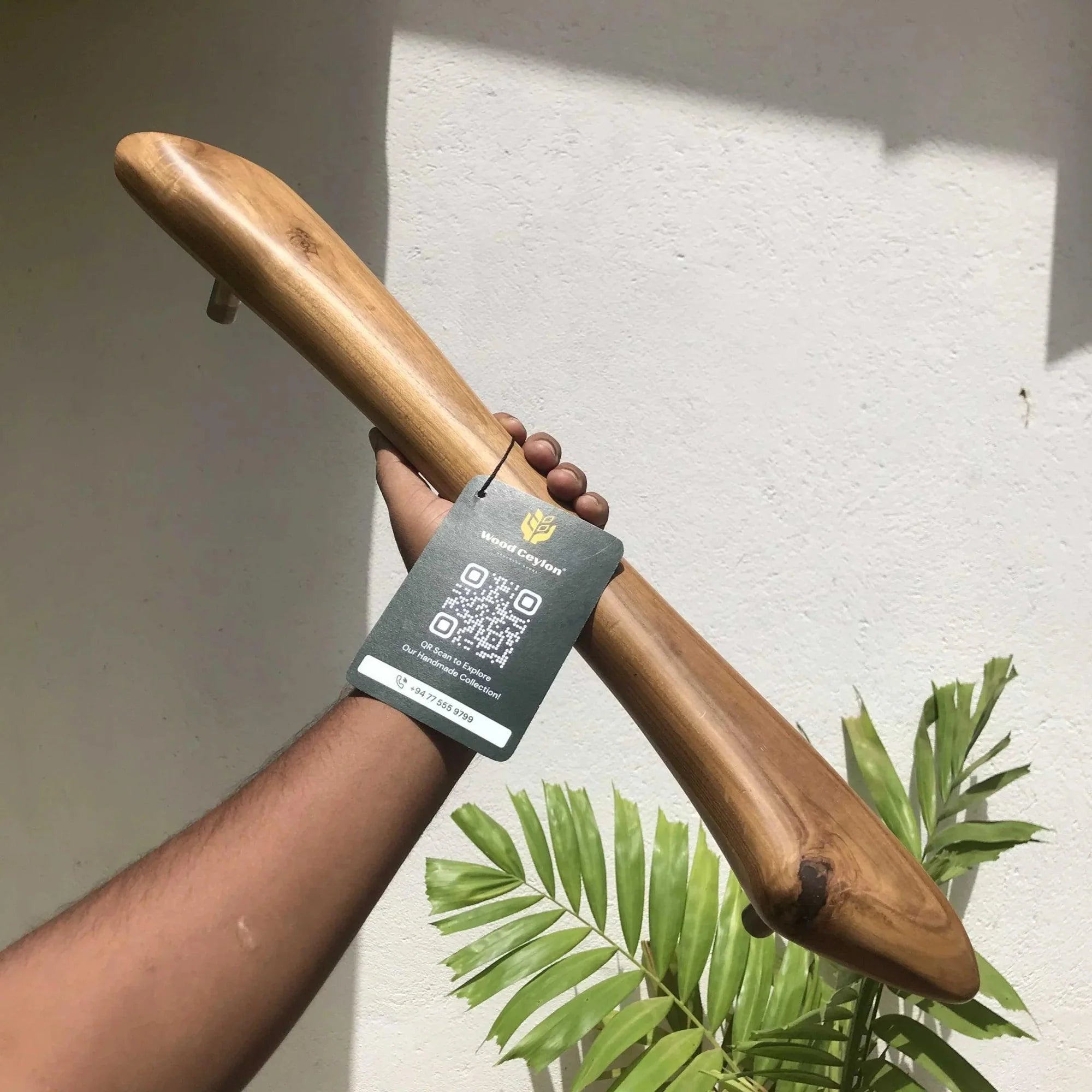 Wood Ceylon wooden front door handle held by hand with natural wood finish and smooth texture