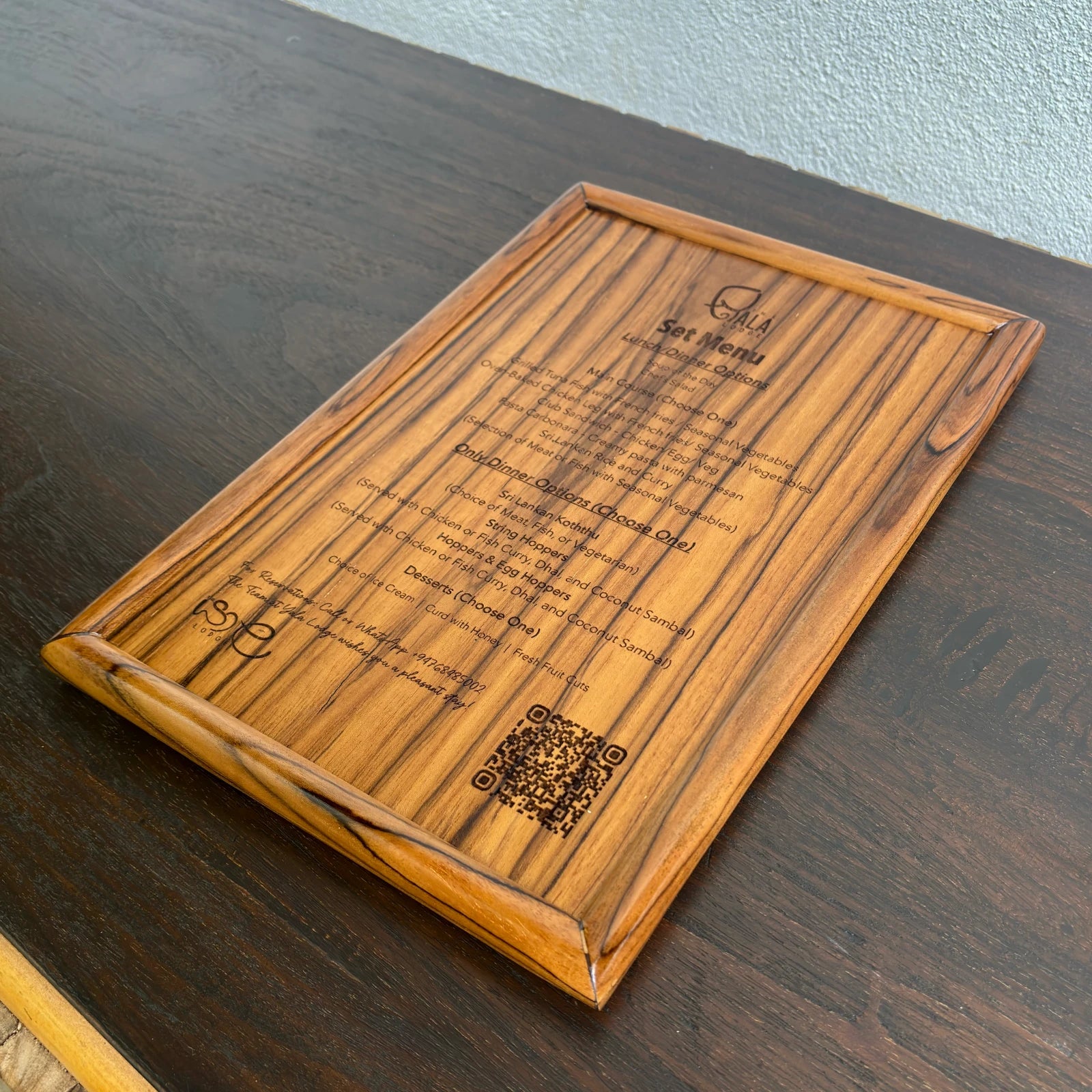 Wood Ceylon wooden laser engraved menu card with detailed food options on a dark wood table