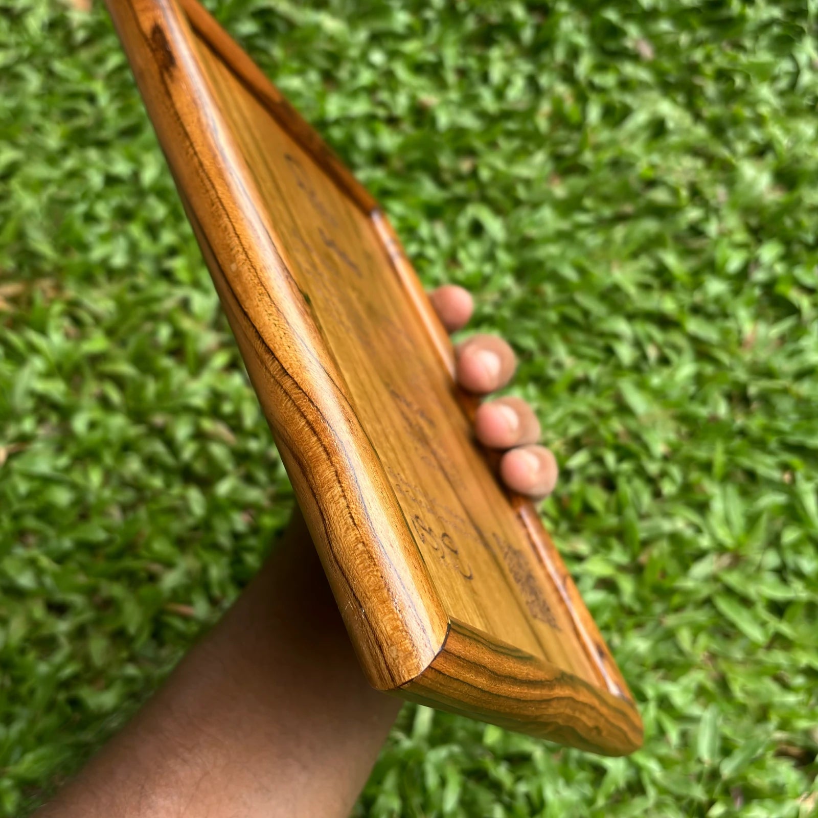 Hand holding a wooden laser engraved menu card with smooth edges and detailed engraving