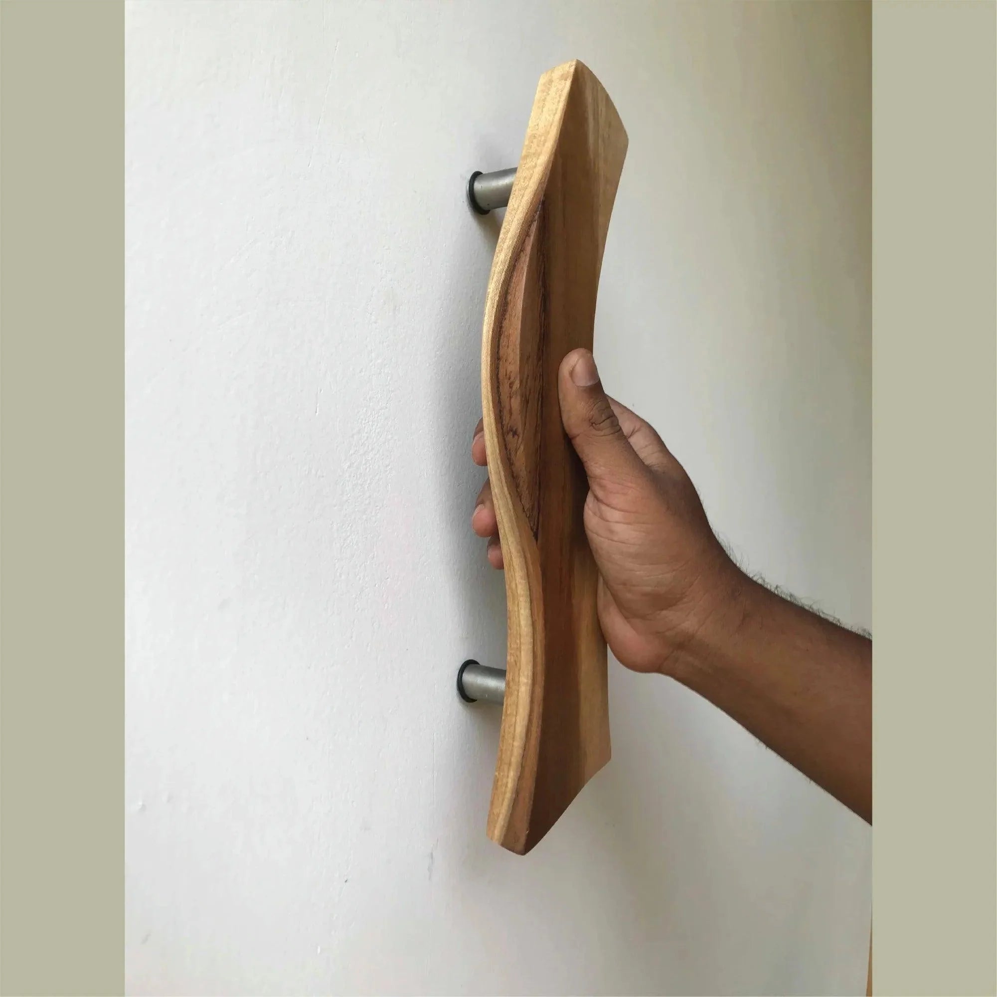 Wood Ceylon wooden Screen Door Handle with ergonomic curved design held by hand on white door