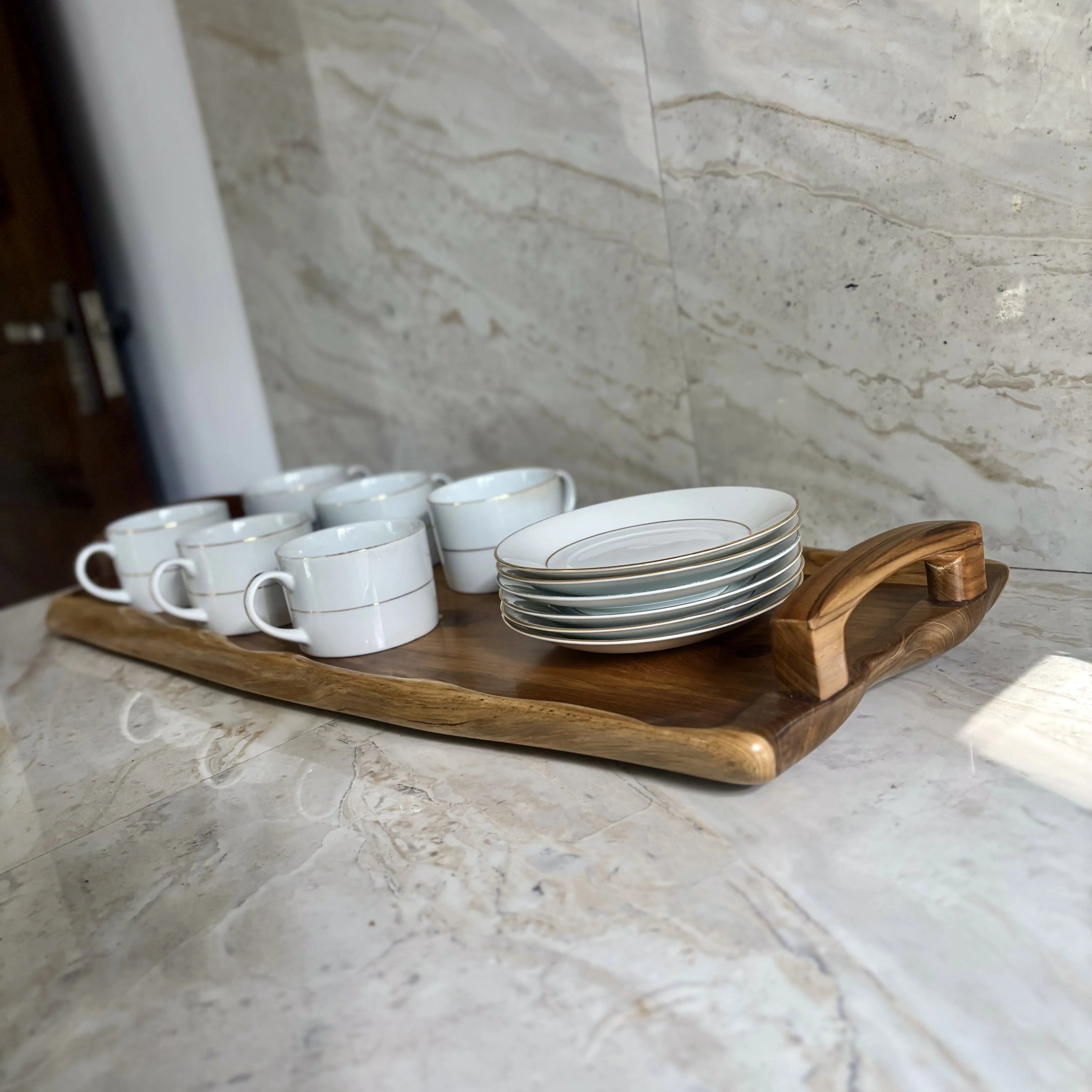 Wood Ceylon wooden serving tray with handle holding white cups and stacked plates on marble surface