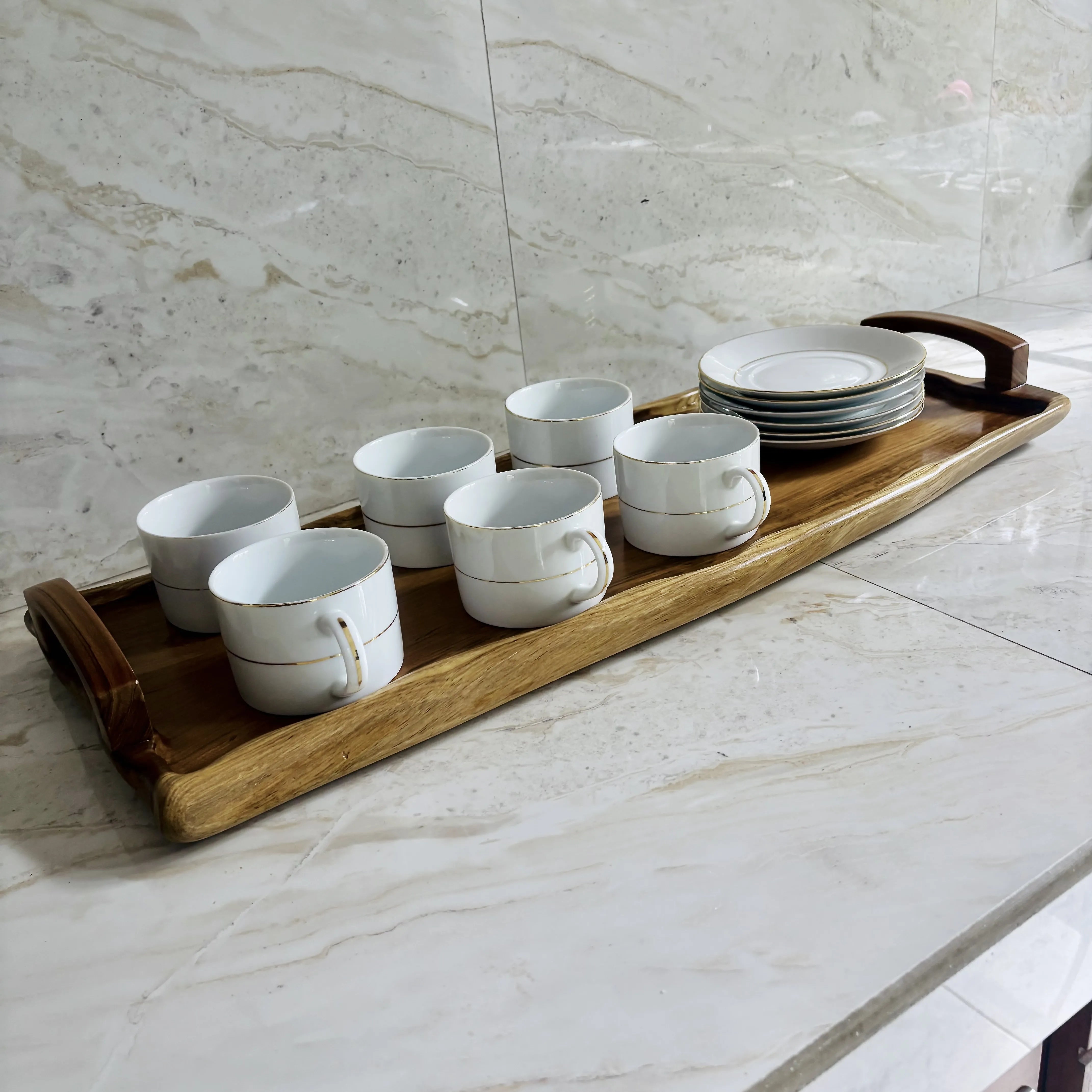 Wood Ceylon wooden serving tray holding six white coffee cups and stacked plates on marble surface