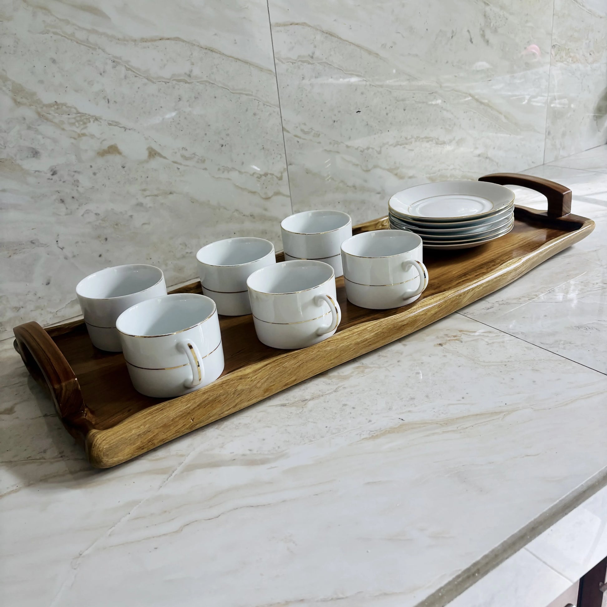 Wood Ceylon wooden serving tray holding six white coffee cups and stacked plates on marble surface