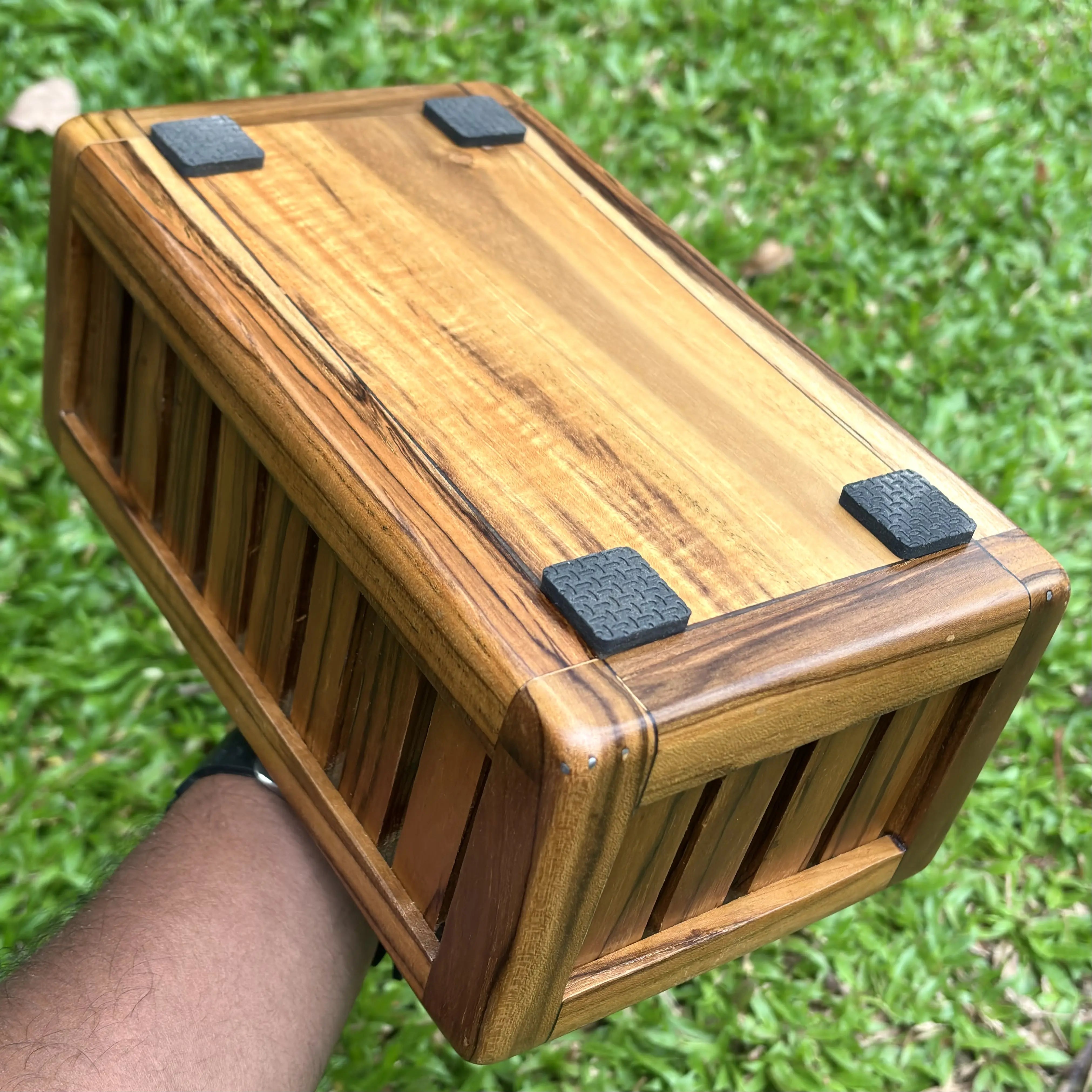 Wood Ceylon wooden towel box storage with smooth finish and black corner protectors held outdoors